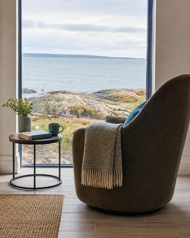 a chair in a living room with a view of the ocean at Atlantic beach house in Dog Island