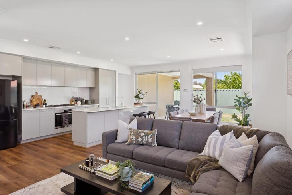 a living room with a couch and a kitchen at The Tobias in Perth