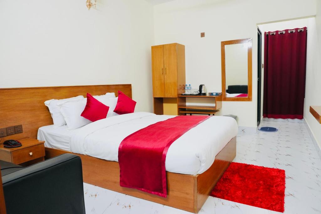 a bedroom with a large bed with a red blanket at Hotel Comfort Inn Sylhet in Sylhet
