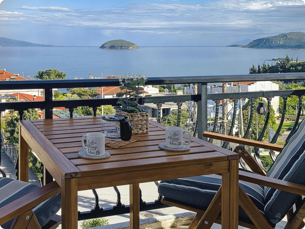 a wooden table on a balcony with a view of the water at Thalassa Beach Kavala in Paleo Tsifliki