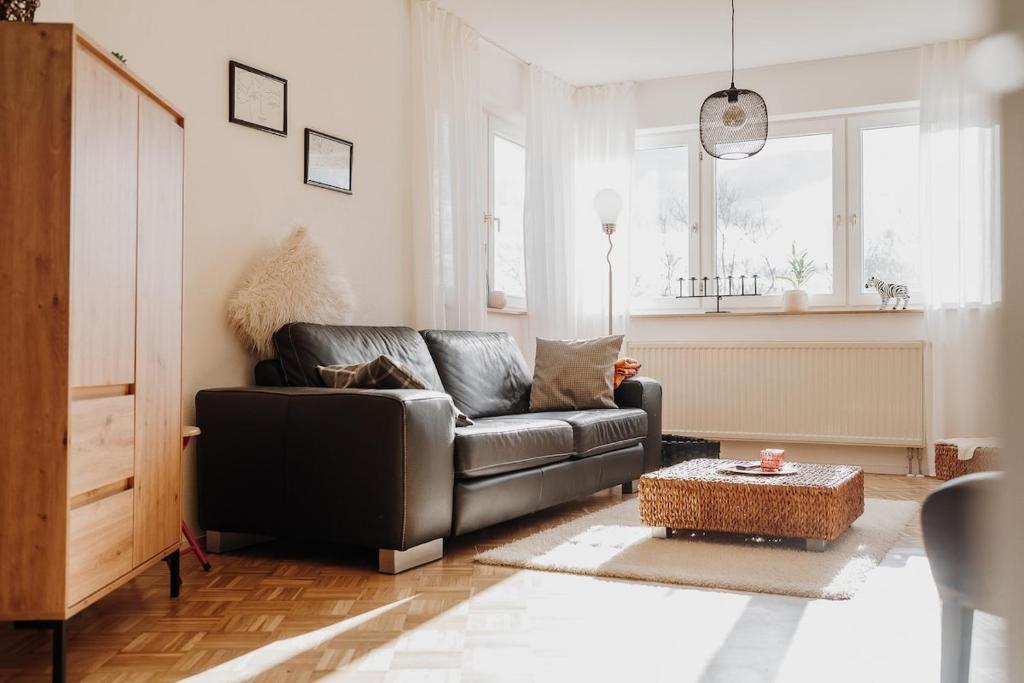 a living room with a leather couch and a table at Gemütliche Ferienwohnung in Riedlingen