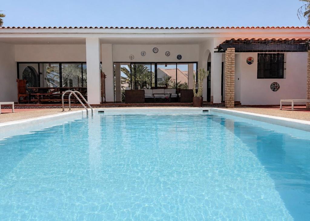 a large blue swimming pool in a house at Miramar Boutique Apartments ADULTS ONLY CORRALEJO in Corralejo