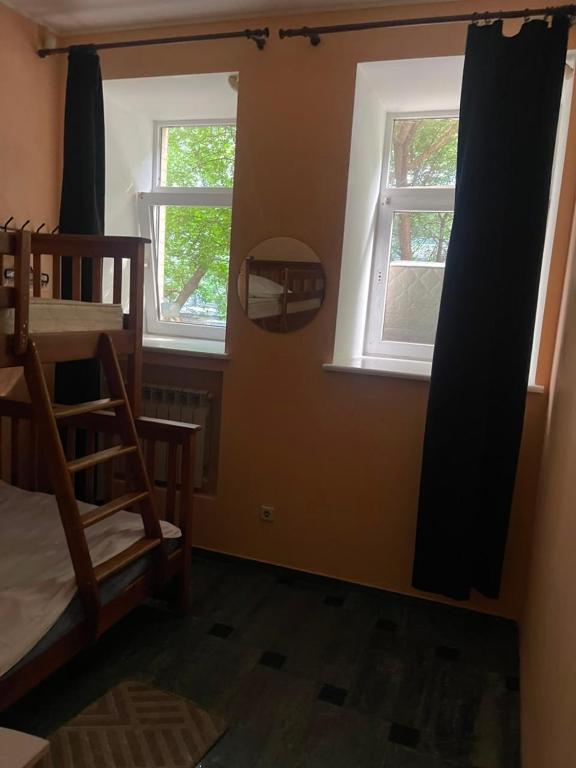 a bedroom with two windows and a bunk bed at Good driams Xoctel in Kyiv