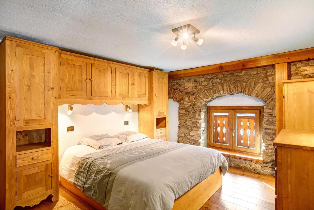 a bedroom with a bed and a stone wall at Chalet vista Monte Bianco in La Salle