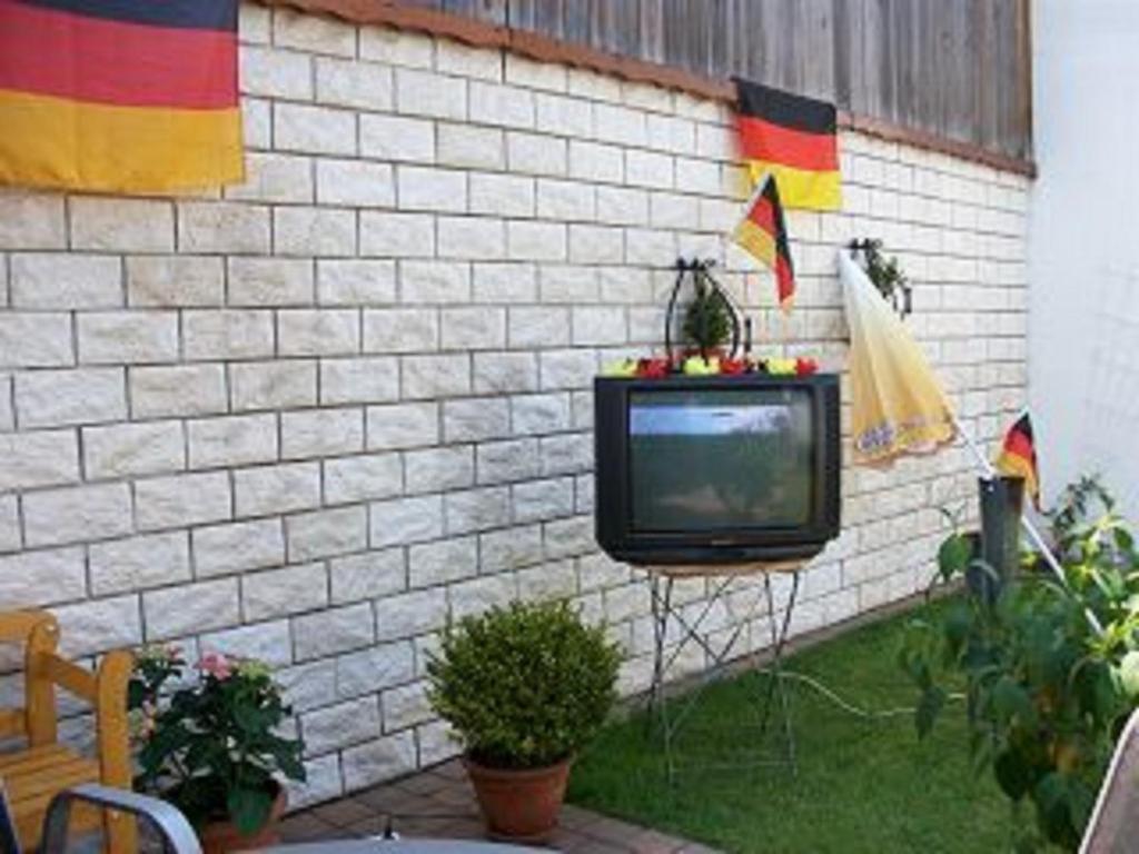 ゲルゼンキルヒェンにあるFerienwohnung Holidayの煉瓦壁の横に座るテレビ