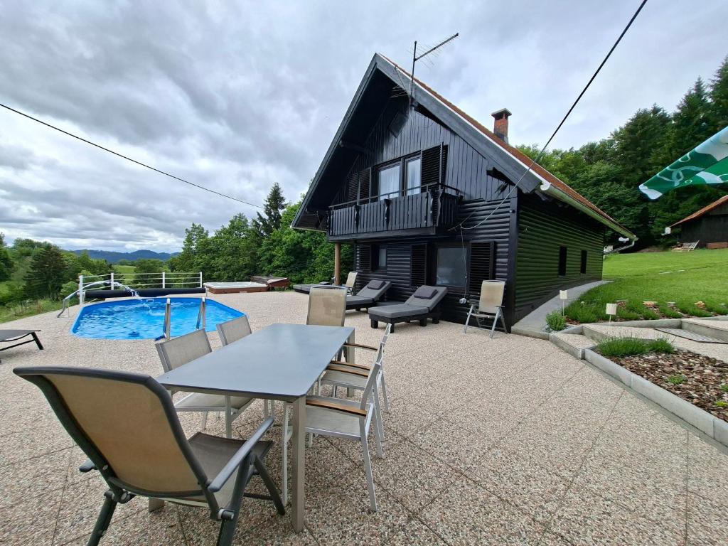 a patio with a table and chairs and a house at House Gore VVV in Dol pri Hrastniku