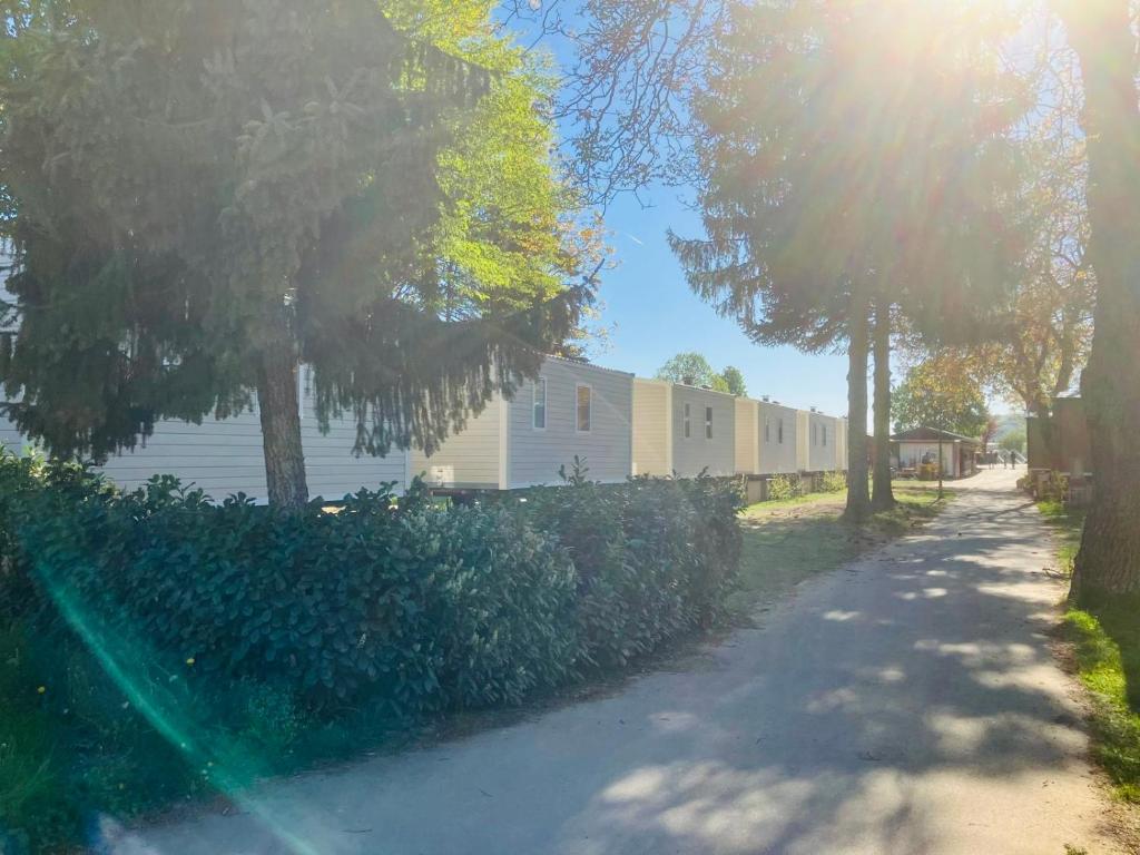 a street in front of a building with trees at Mobile Home Simplicity - Camp Diekirch in Gilsdorf