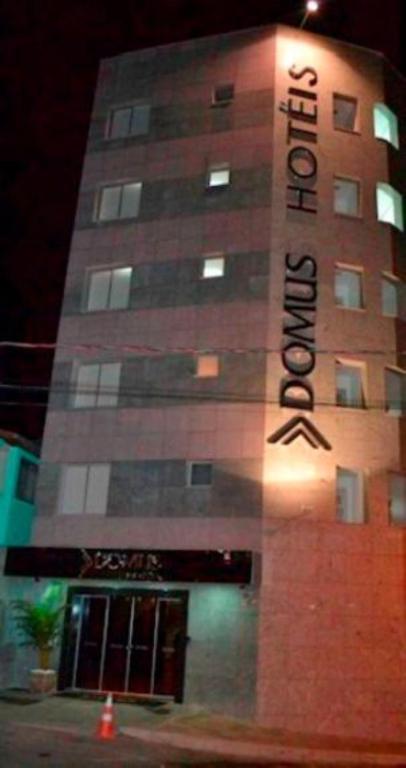 a building with a sign that reads the hotel at Hotel Domus Itabira in Itabira