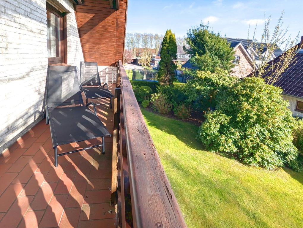 a porch with two chairs on the side of a house at Wohnung Gesa in Alkersum in Alkersum