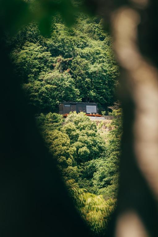a train traveling through a lush green forest at 森の宿 l ACAO FOREST 01 in Atami