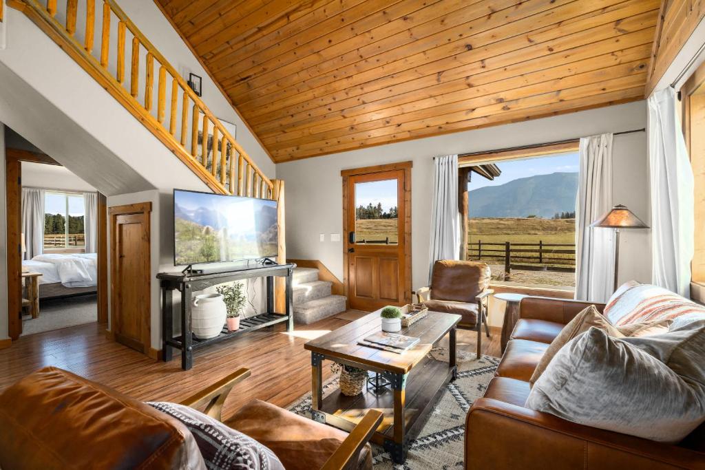 a living room with a couch and a tv at Glacier River Ranch - Middle Fork in Columbia Falls