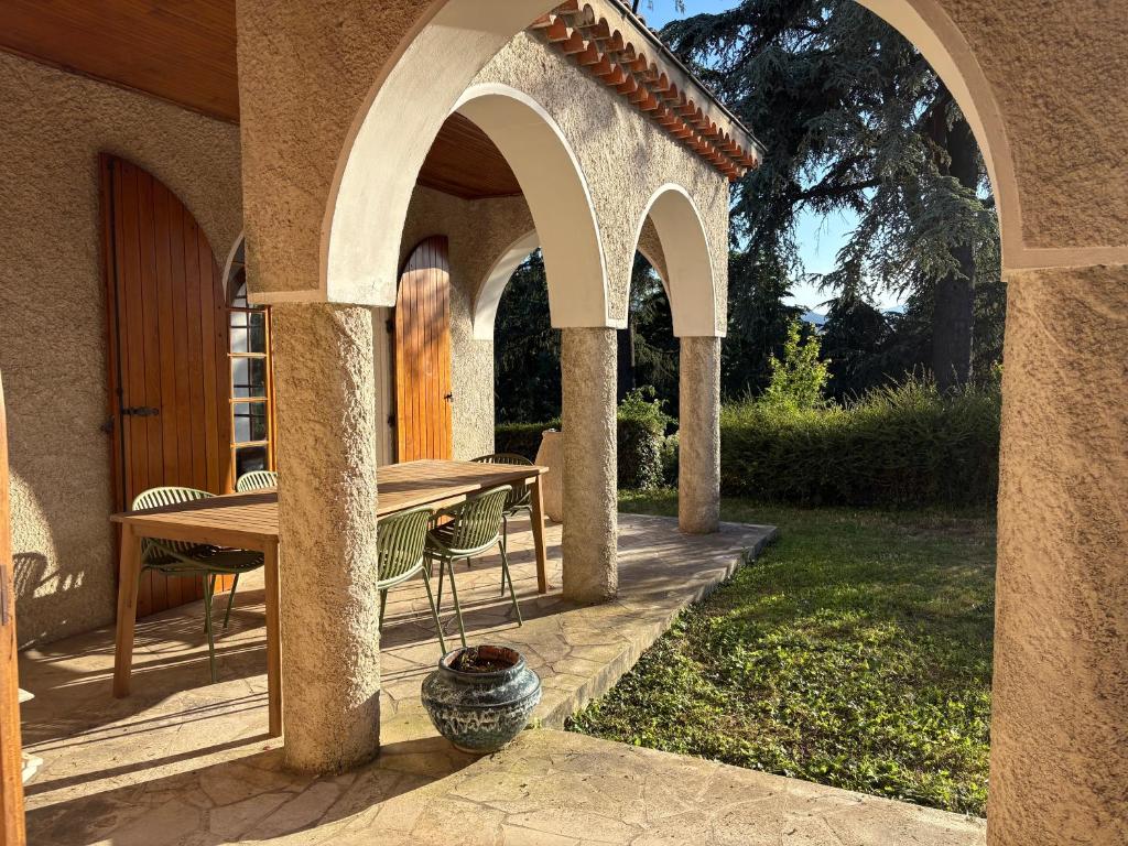 an outdoor patio with a wooden table and chairs at Los Arcos in Annonay