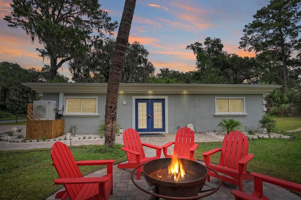 a fire pit in front of a house with red chairs at Battery Place in Savannah