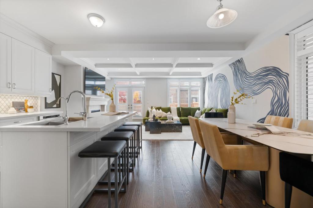 a kitchen and living room with a counter and chairs at The Oakville House in Oakville