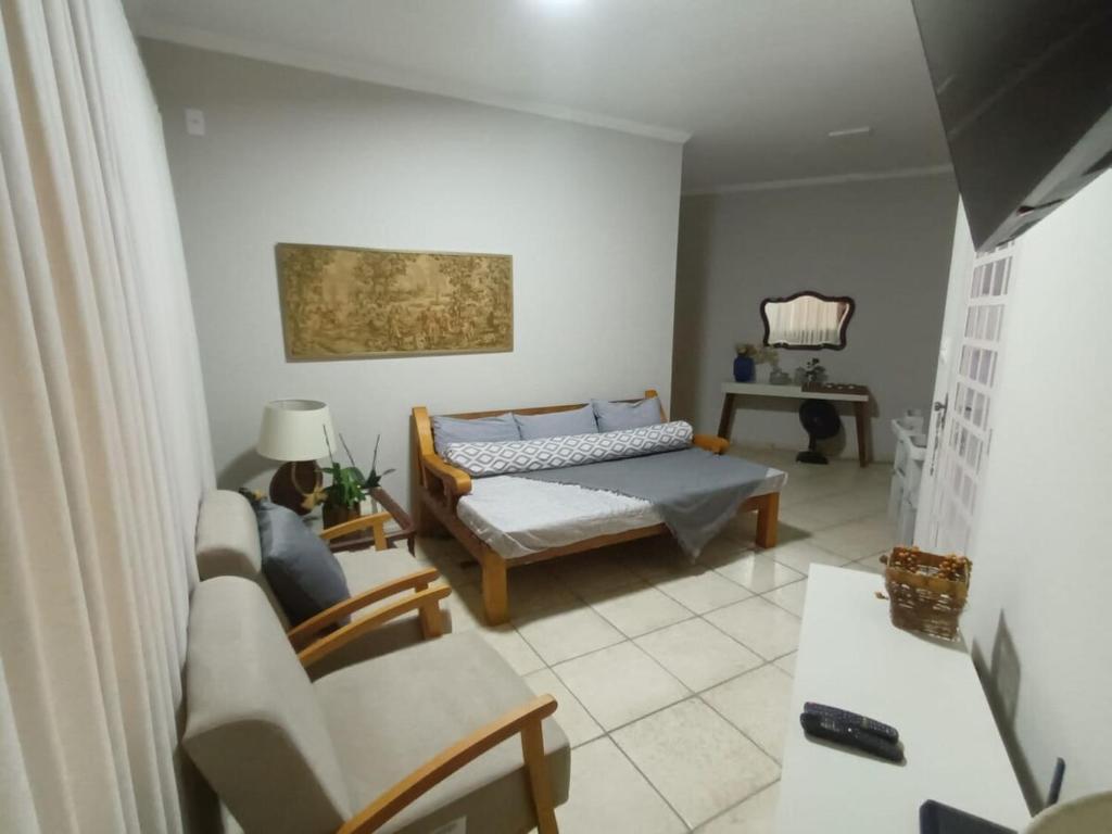 a living room with a bed and a couch at Confortável e bem localizada, com 2 quartos e garagem in São João da Boa Vista