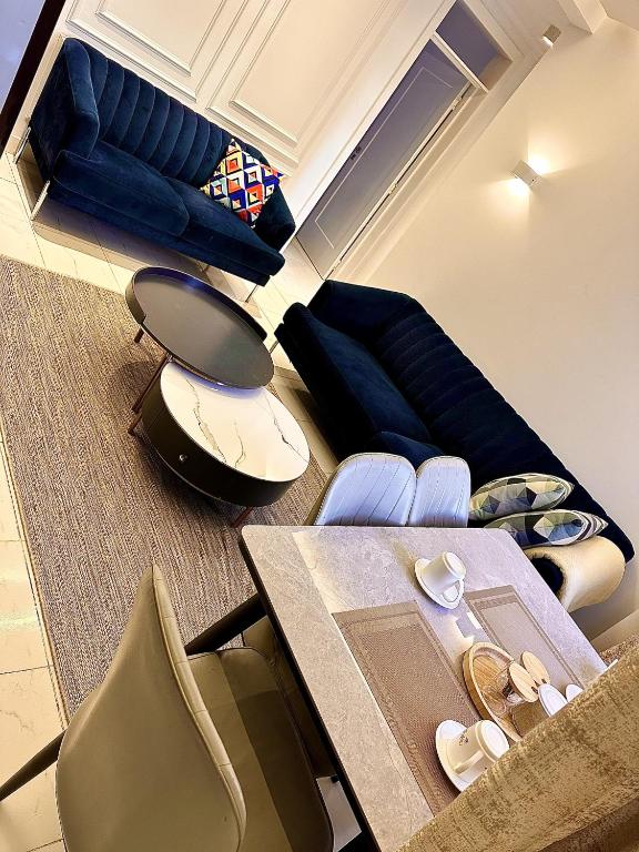 ein Wohnzimmer mit Sofa, Tisch und Stühlen in der Unterkunft Residence Next Door Green Zone in Kiambu