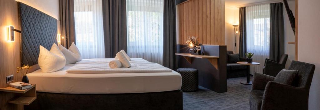 a hotel room with a large bed and a chair at Hotel Zum Steinhof in Bad Blankenburg