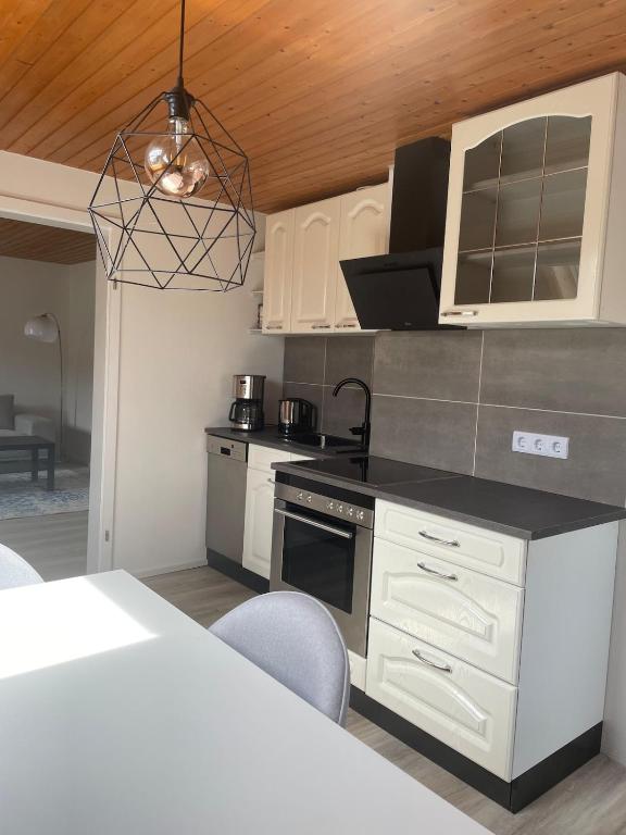 a kitchen with white cabinets and a black counter top at Apartment Kuhl in Selb