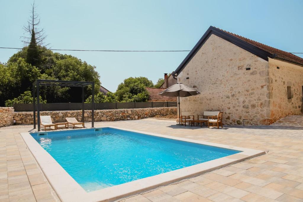 a swimming pool in front of a house at Aurora in Ljubuški
