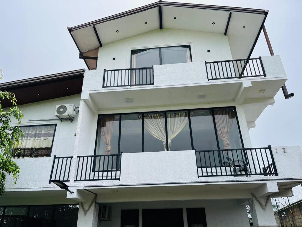 a white building with balconies and windows at N4 Rest Hanthana in Etulgama