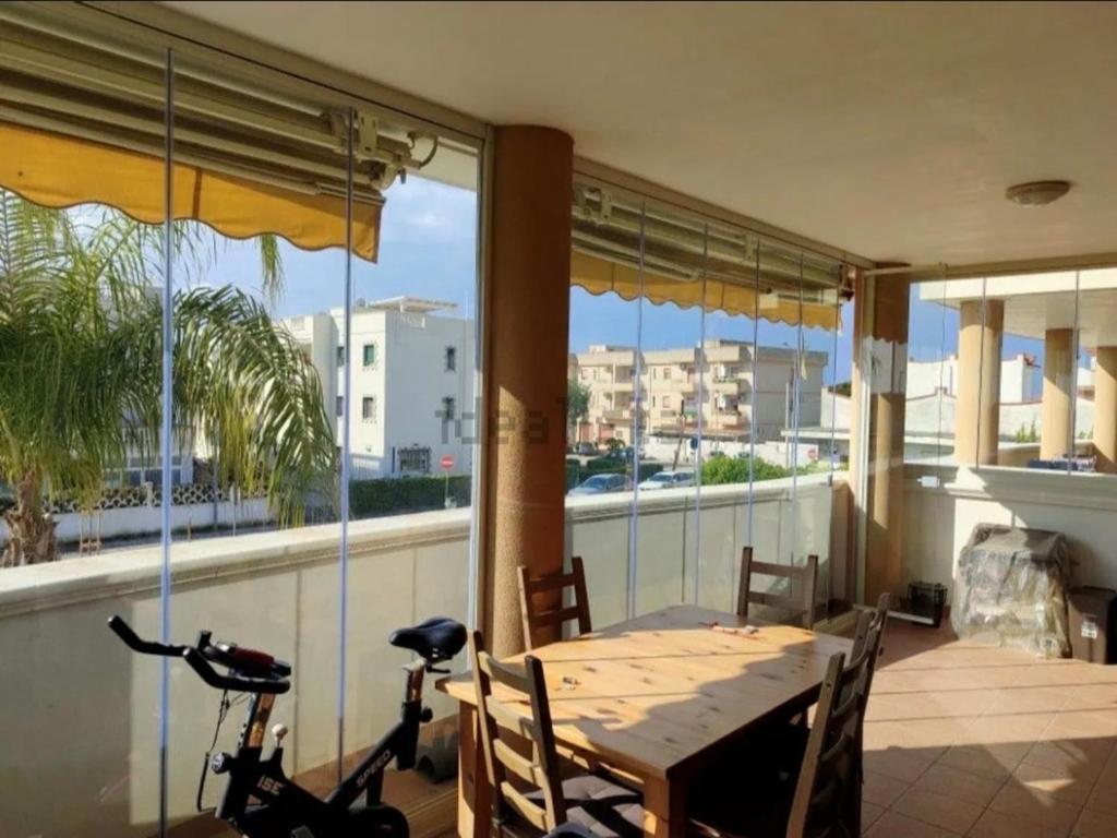 a dining room with a table and a bike on a balcony at Casa Vacanze "LA TERRAZZA" in Leporano