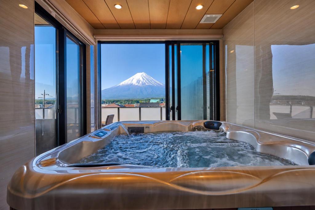 a tub in a room with a mountain in the background at Miire Mt Fuji Forest in Fujikawaguchiko