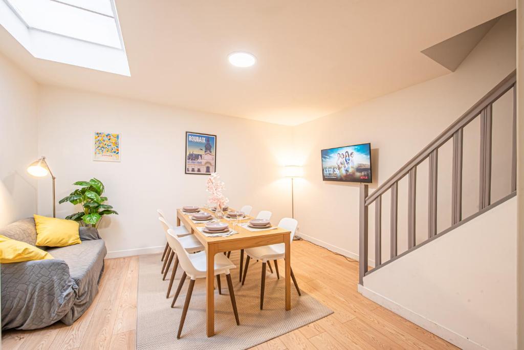 a dining room and living room with a table and a couch at Maison Cuvier - Spacieuse Maison Idéale Groupes & Pros in Roubaix