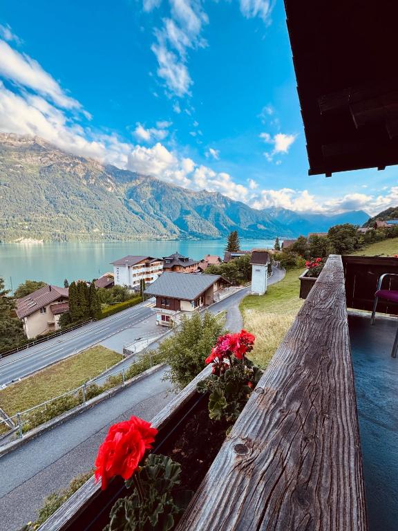 a view from the balcony of a house with flowers at Chalet Luna - Alpine Apartment by Lake Brienz in Niederried