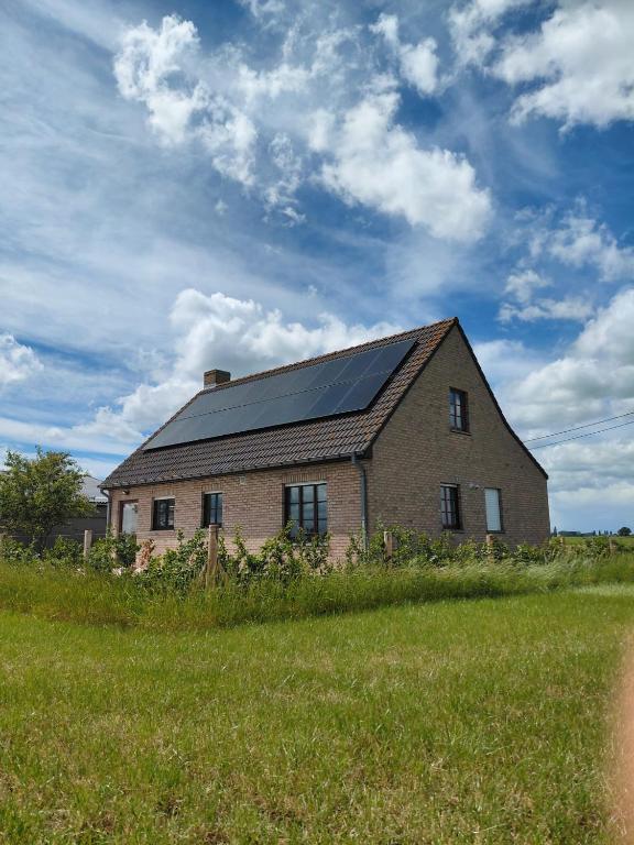 a large brick house with solar panels on the roof at 't Ooievaarszicht in Veurne