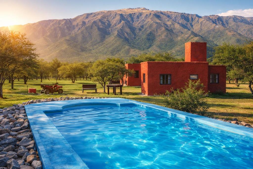a pool in front of a house with mountains in the background at Cabañas Calma Chicha in Cortaderas