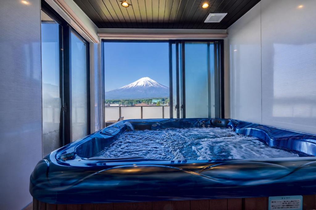 a blue tub in a room with a mountain view at Miire Mt Fuji Traditional in Fujikawaguchiko