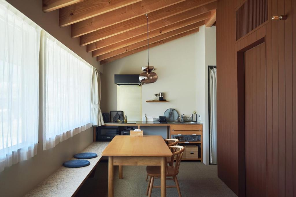 a kitchen with a table and chairs in a room at SUISUI Hakushu Hotel in Shirasu
