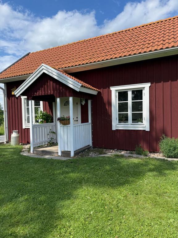 a red house with a red roof at Brygghuset between Hjo and Tidaholm in Hjo