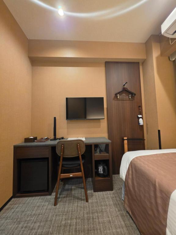 a hotel room with a desk and a television at Hotel Matsunoi Shurin in Tokyo