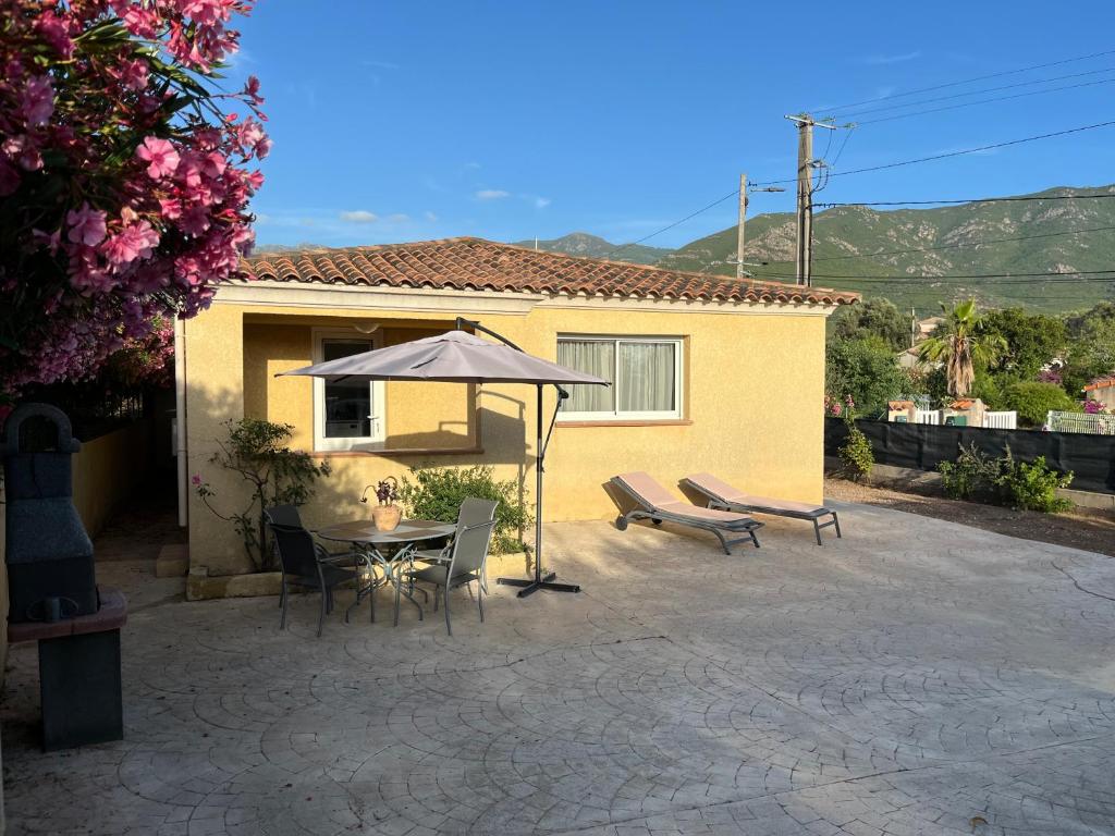 a patio with a table and an umbrella and a bench at CASA Petra Rosa in Peri