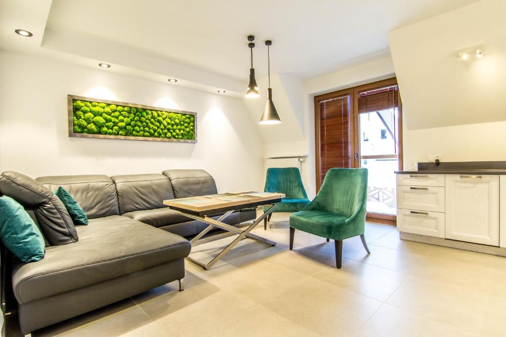 un soggiorno con divano, tavolo e sedie di Apartamenty Szkolna Zakopane a Zakopane