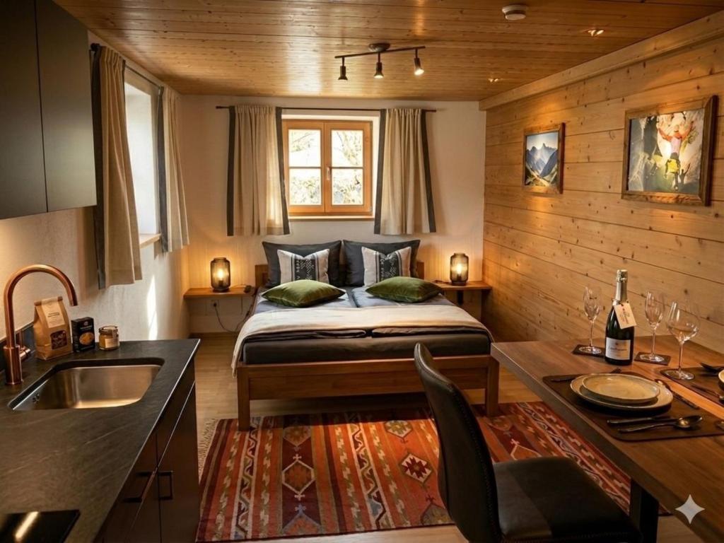 a bedroom with a bed and a kitchen with a sink at Fewo TG in Schliersee