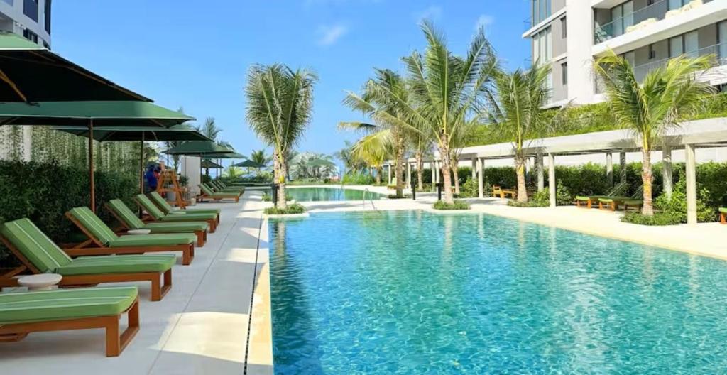 a swimming pool with chaise lounge chairs and palm trees at Apartamento en Manzanillo con salida directa a la playa in Cartagena de Indias