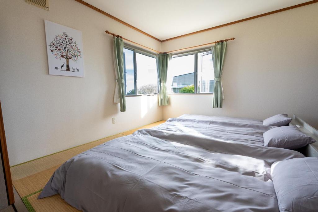 a bedroom with a large bed and a window at Seaside Deer Shiraoi in Shiraoi