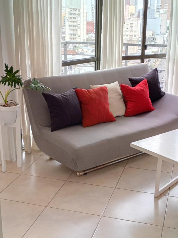 a couch with four pillows on it in a living room at Apartamento 4 de Enero in Santa Fe