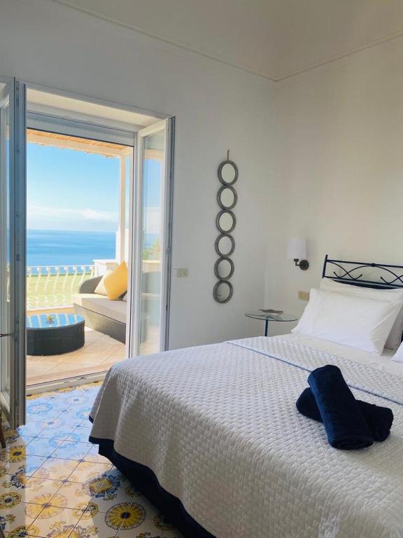 a bedroom with a bed and a view of the ocean at Villa La Panoramica Sea View in Capri
