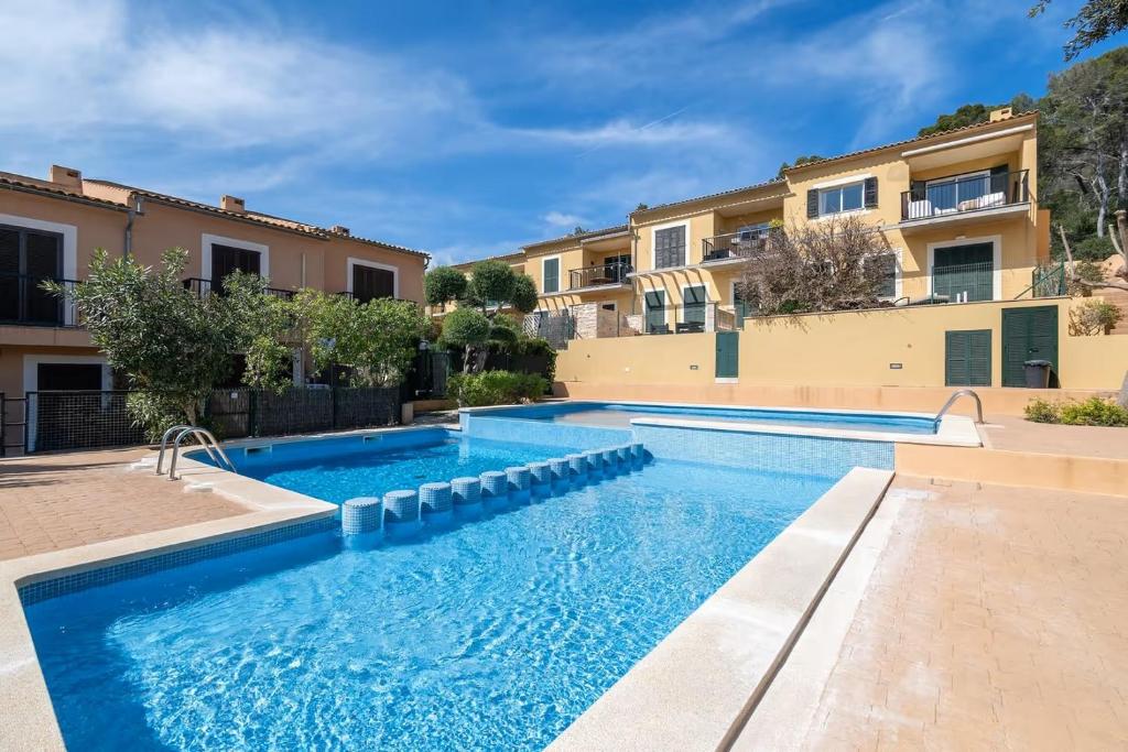 a swimming pool in front of a building at Casa Es Putxet in Cala Ratjada