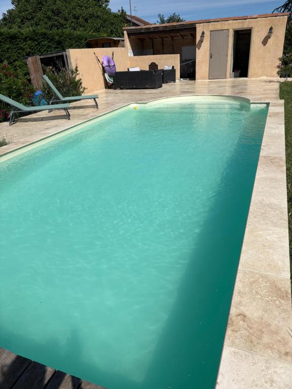 a large swimming pool with a turquoise at Chicken roulotte des 3 cèdres in Cavaillon