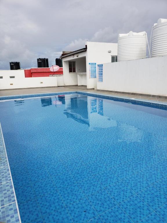 a large blue swimming pool next to a building at SPACIOUS VIP 1 BEDROOM with ROOFTOP SWIMMING POOL AVAILABLE in Mtwapa