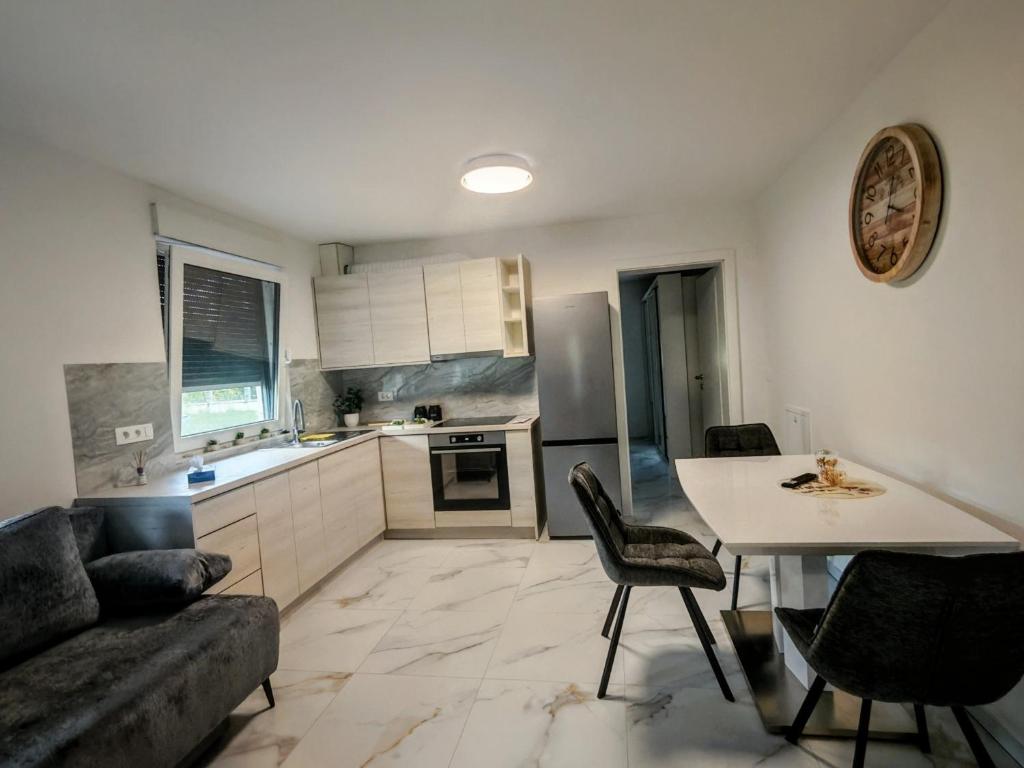 a kitchen with a couch and a table and chairs at Apartma Alpine Gateway in Komenda
