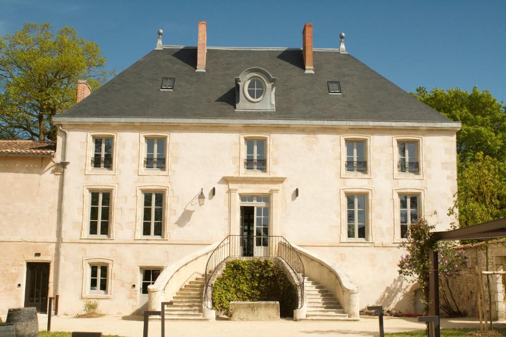 an old house with stairs in front of it at Coureilles Appartements et Suites in La Rochelle