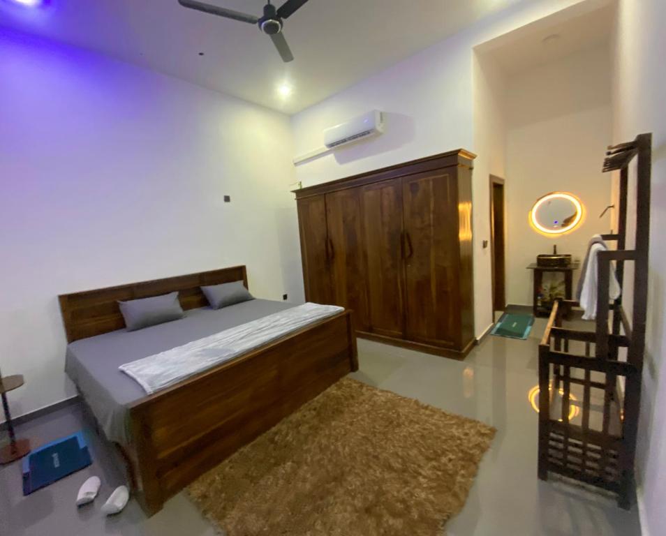 a bedroom with a wooden bed and a rug at ZEN House Arugambay in Arugam Bay