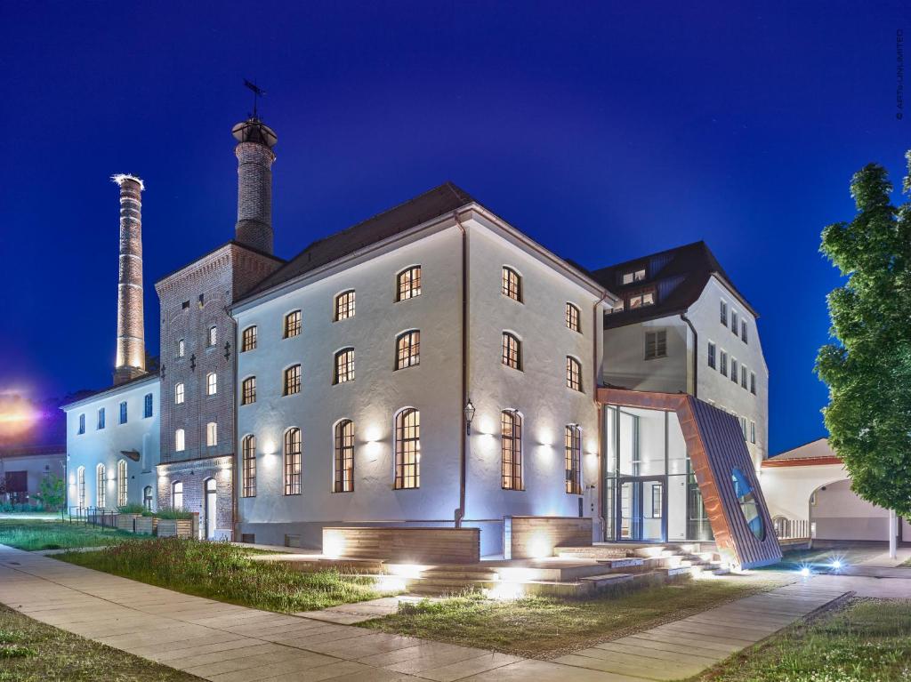 ein Gebäude mit zwei Schornsteinen bei Nacht in der Unterkunft Hotel im Sud in Eggenfelden