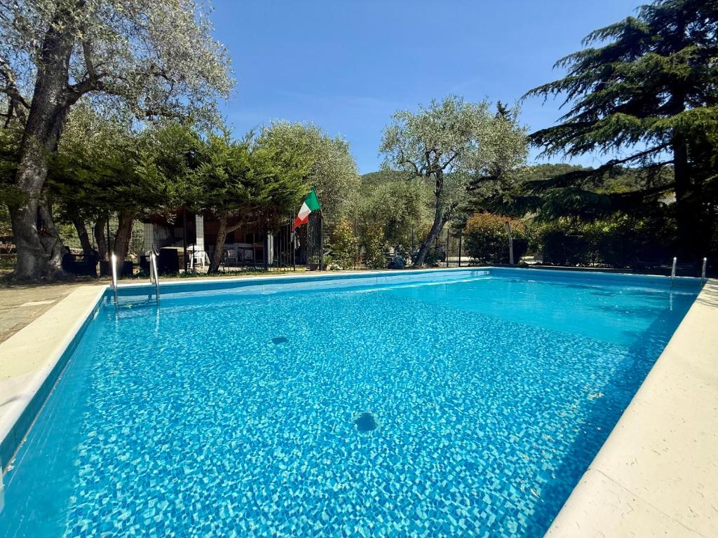 a large blue swimming pool with trees in the background at Ulivo Liguria With pool in Gazzelli