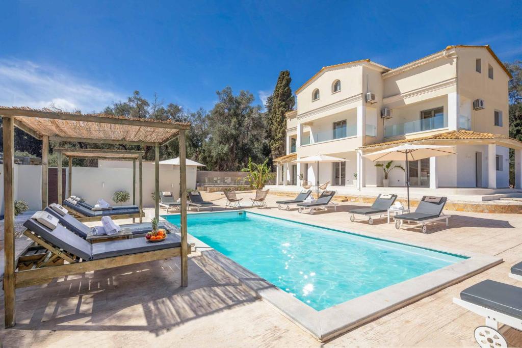 a villa with a swimming pool and a house at Villa Elegio in Kavos